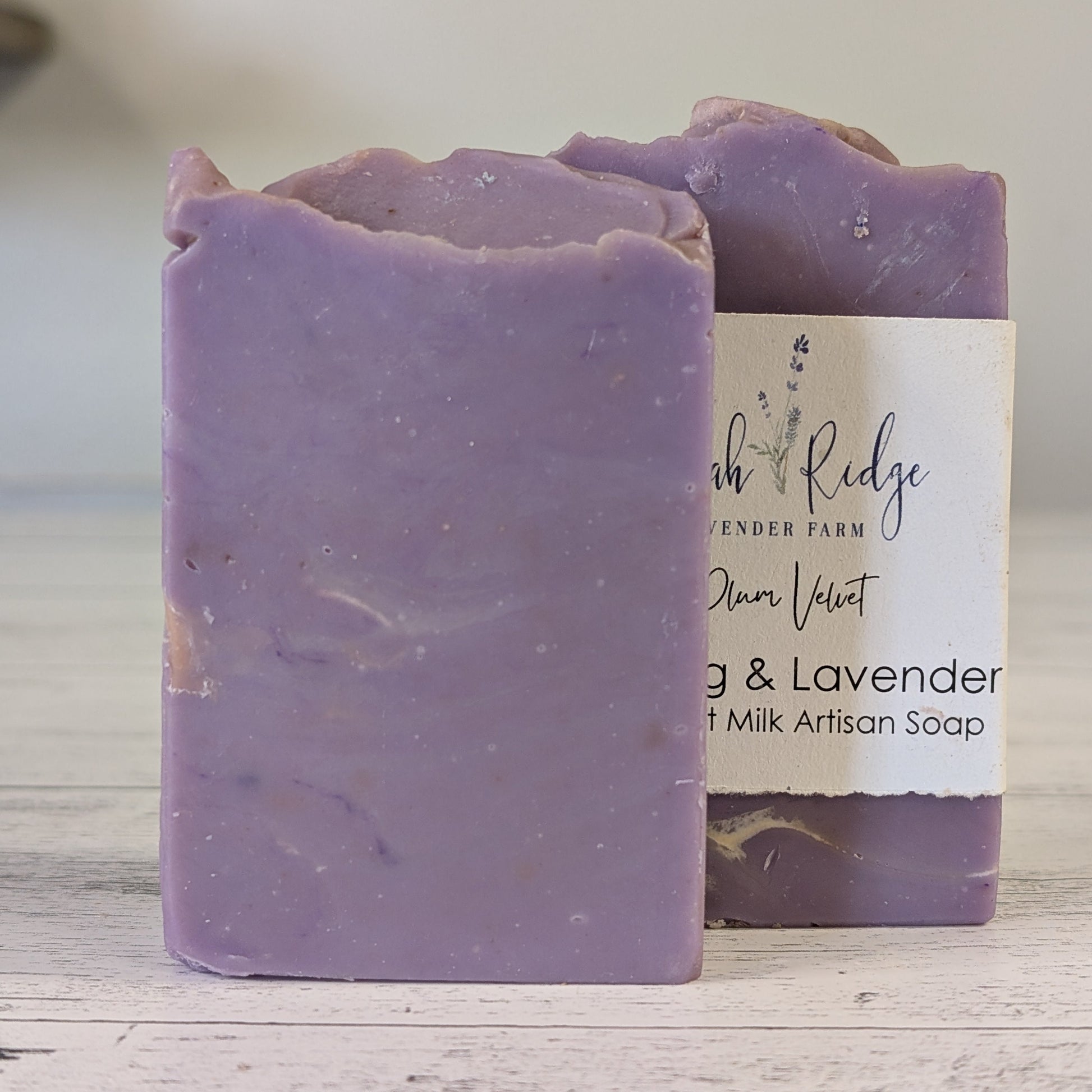 Purple soap bar with a white label on a wooden surface