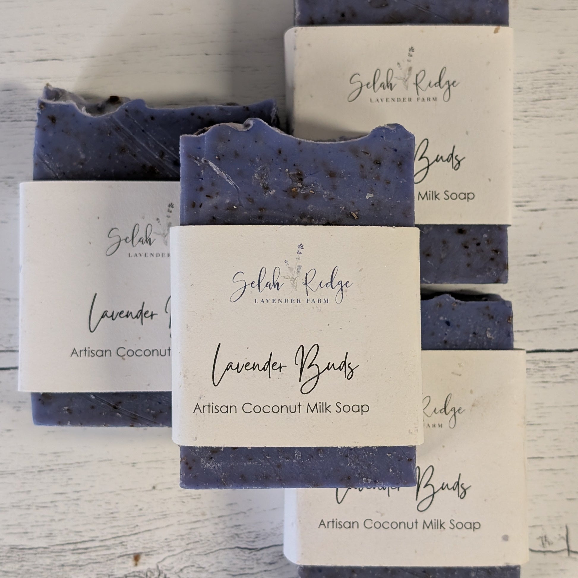 Artisan coconut milk soap bars with labels on a wooden surface