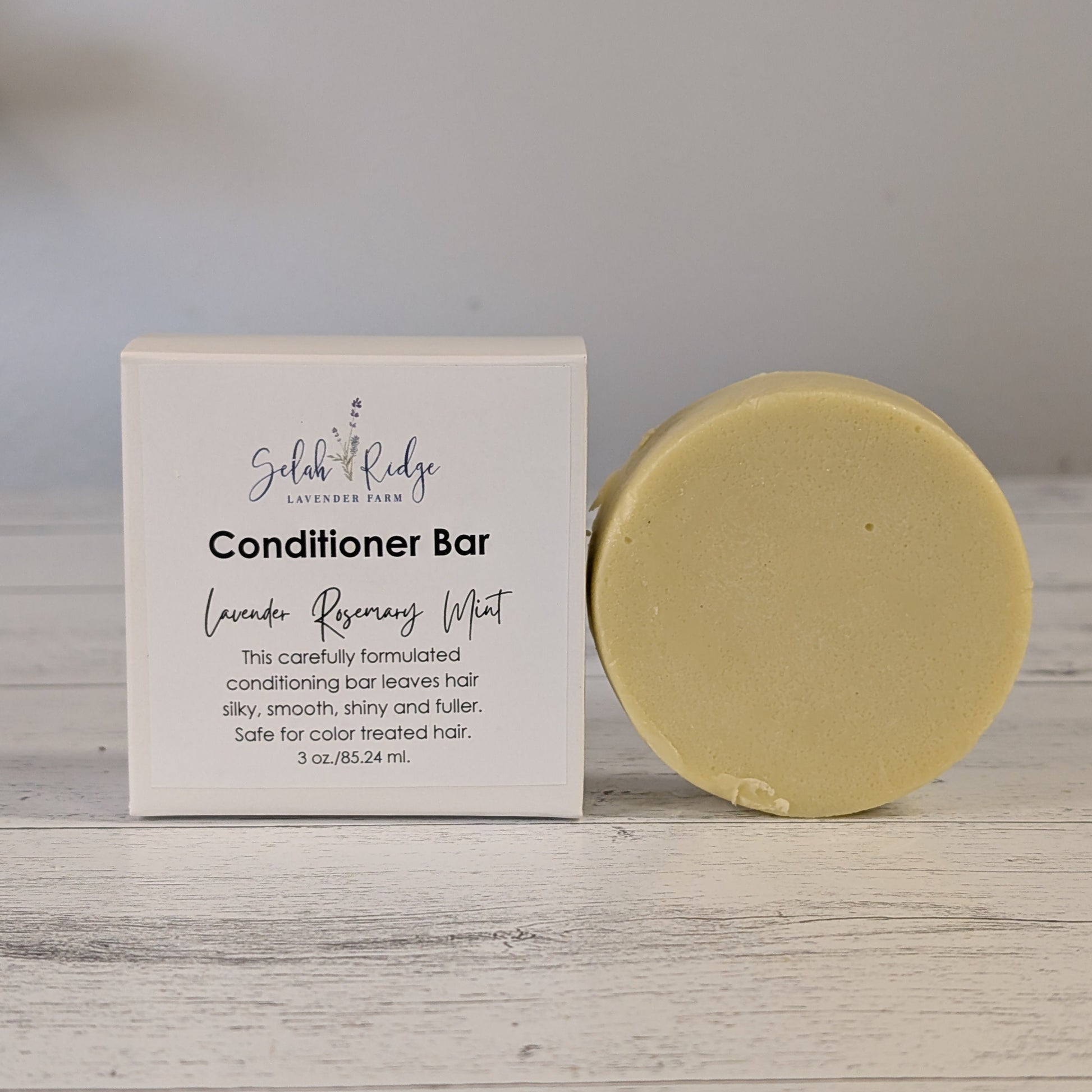 Yellow conditioner bar next to its packaging on a wooden surface