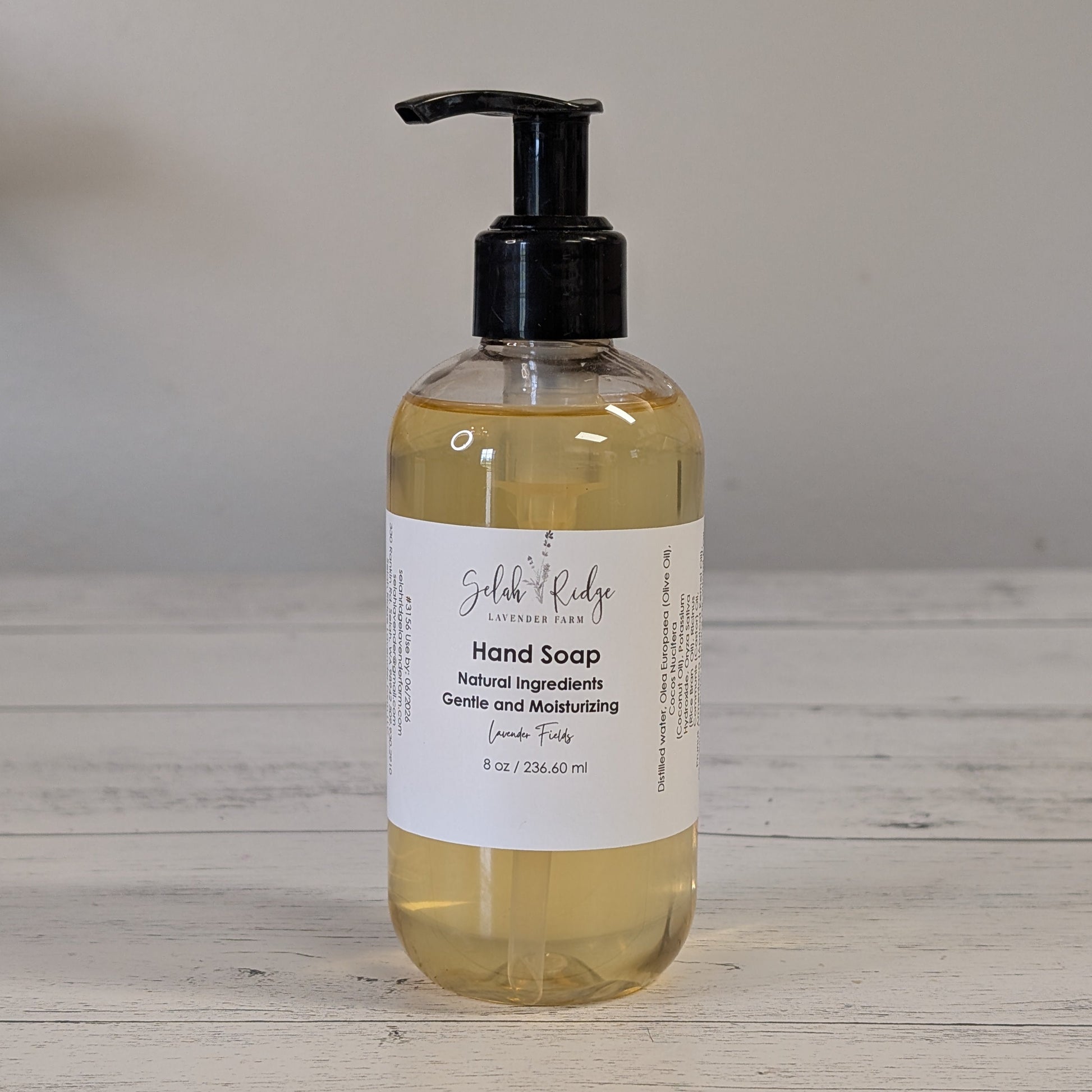 Hand soap bottle with pump on a wooden surface