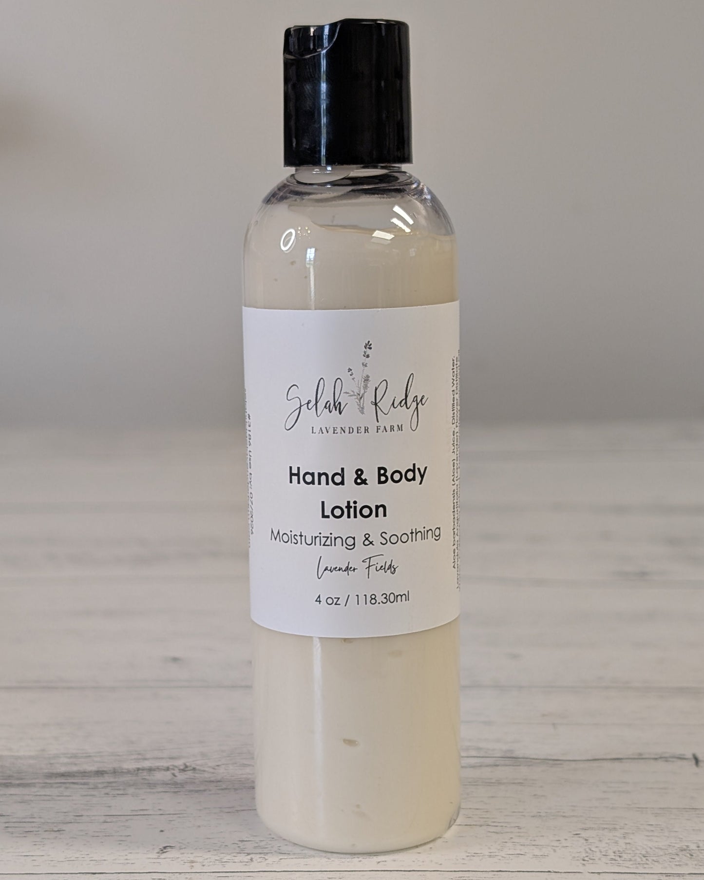 Hand and body lotion bottle with a label on a wooden surface