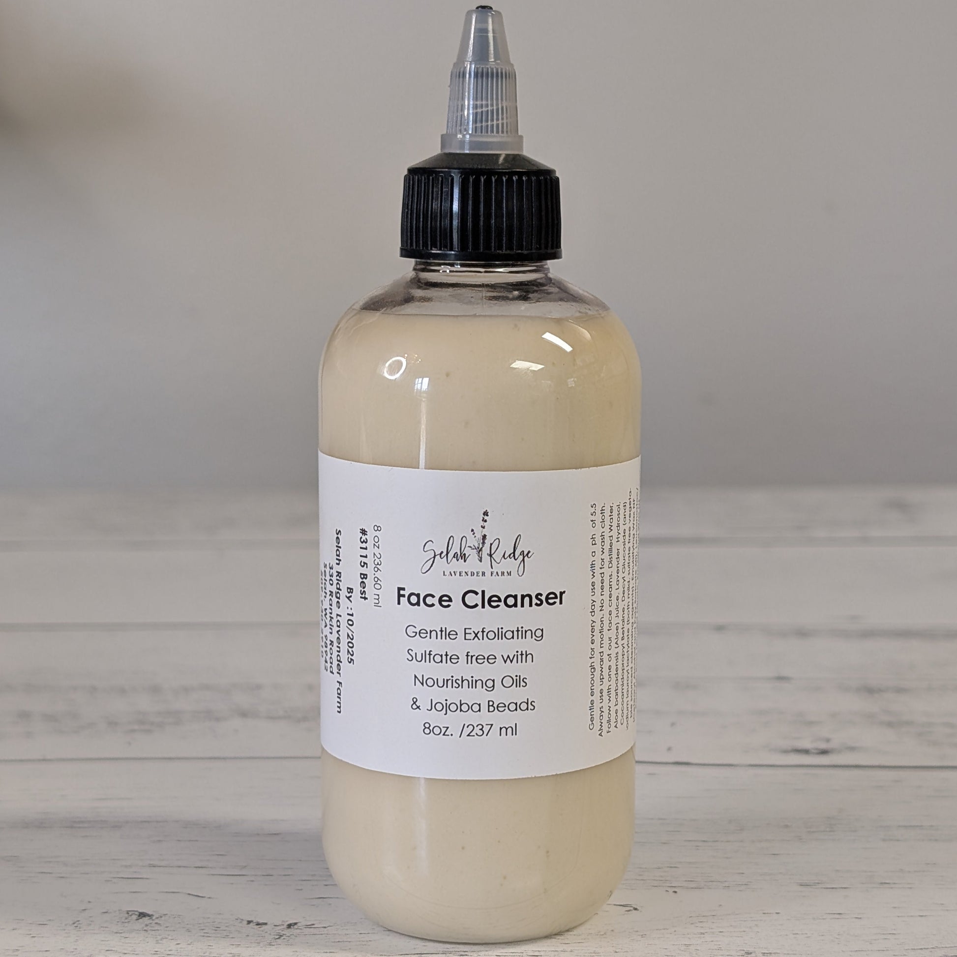 Bottle of face cleanser with a label on a wooden surface