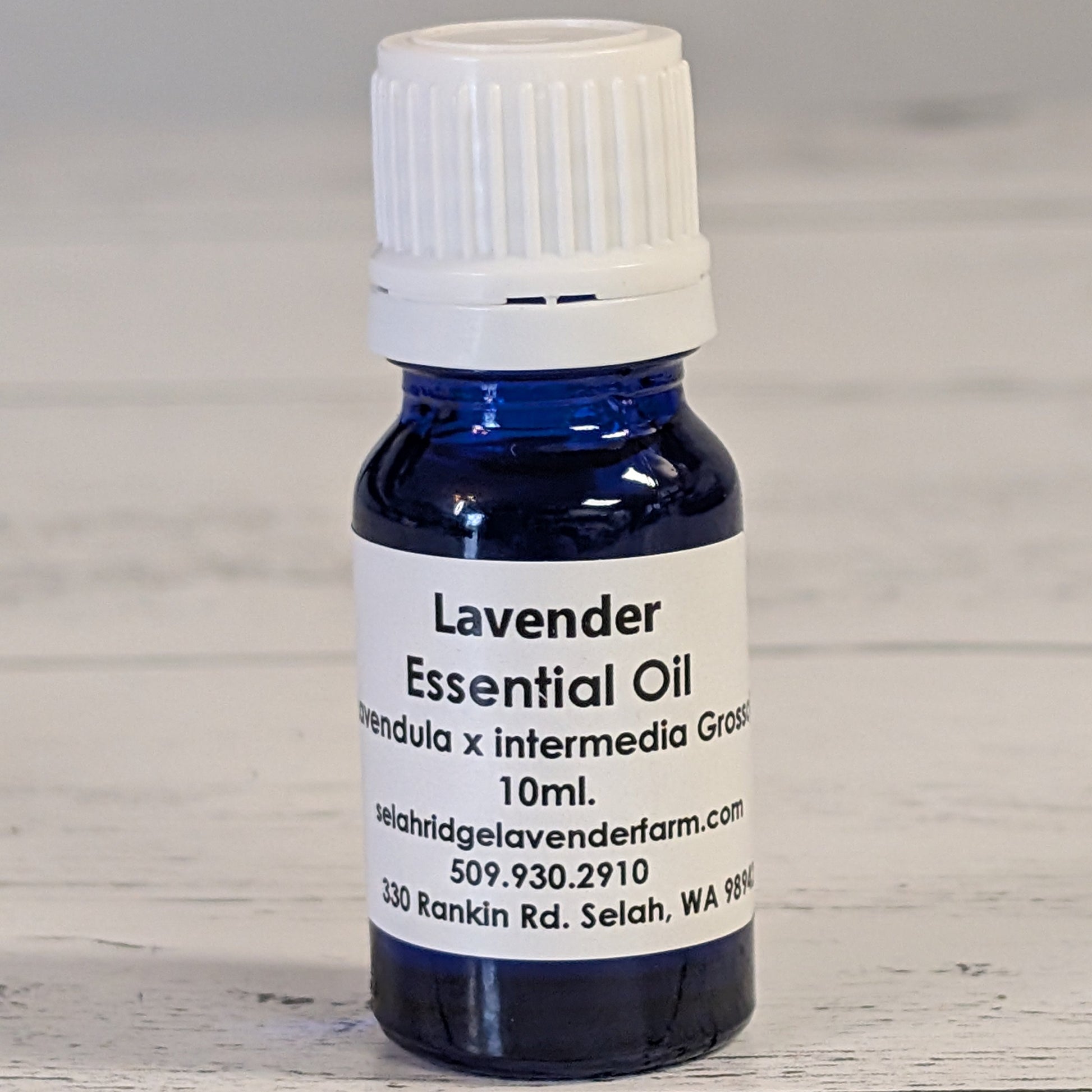 Bottle of lavender essential oil with a white label on a wooden surface
