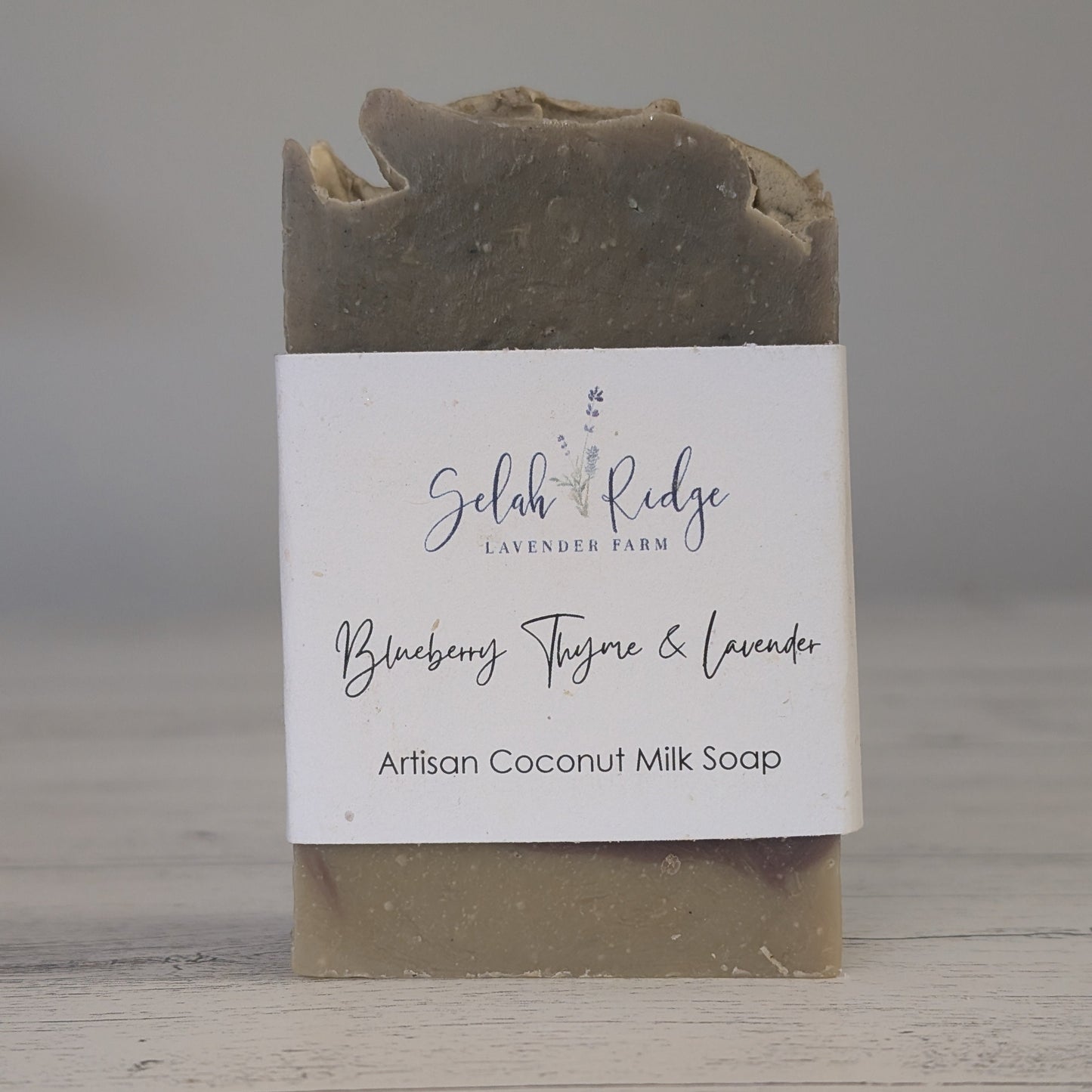 Artisan coconut milk soap bar with a label on a wooden surface