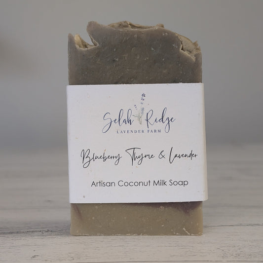 Artisan coconut milk soap bar with a label on a wooden surface
