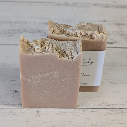Two bars of soap on a wooden surface with a visible brand label.