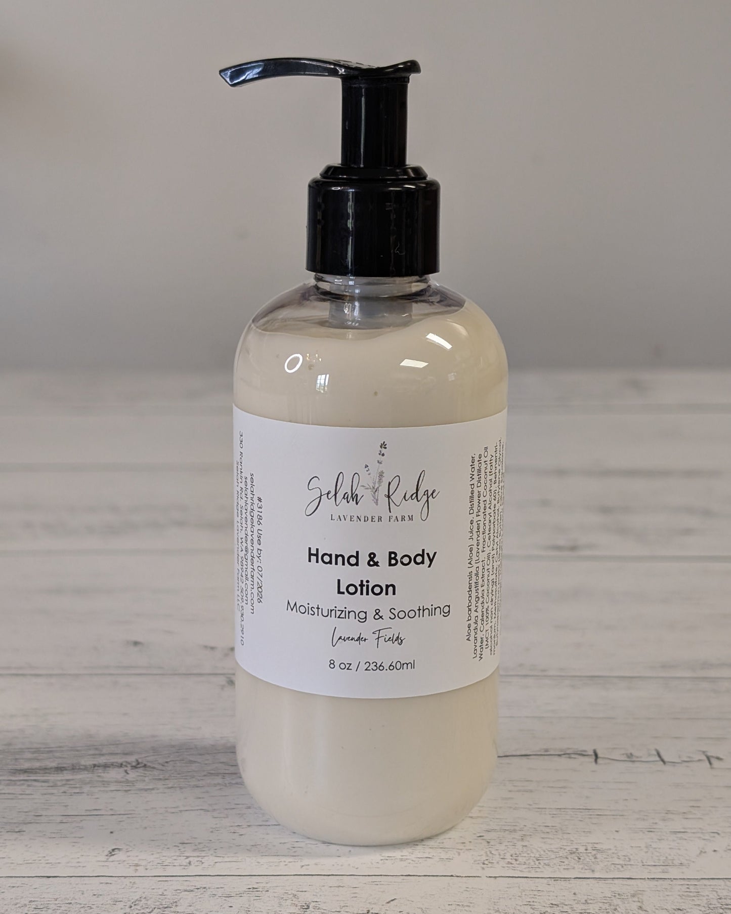 Hand and body lotion bottle with pump on a wooden surface