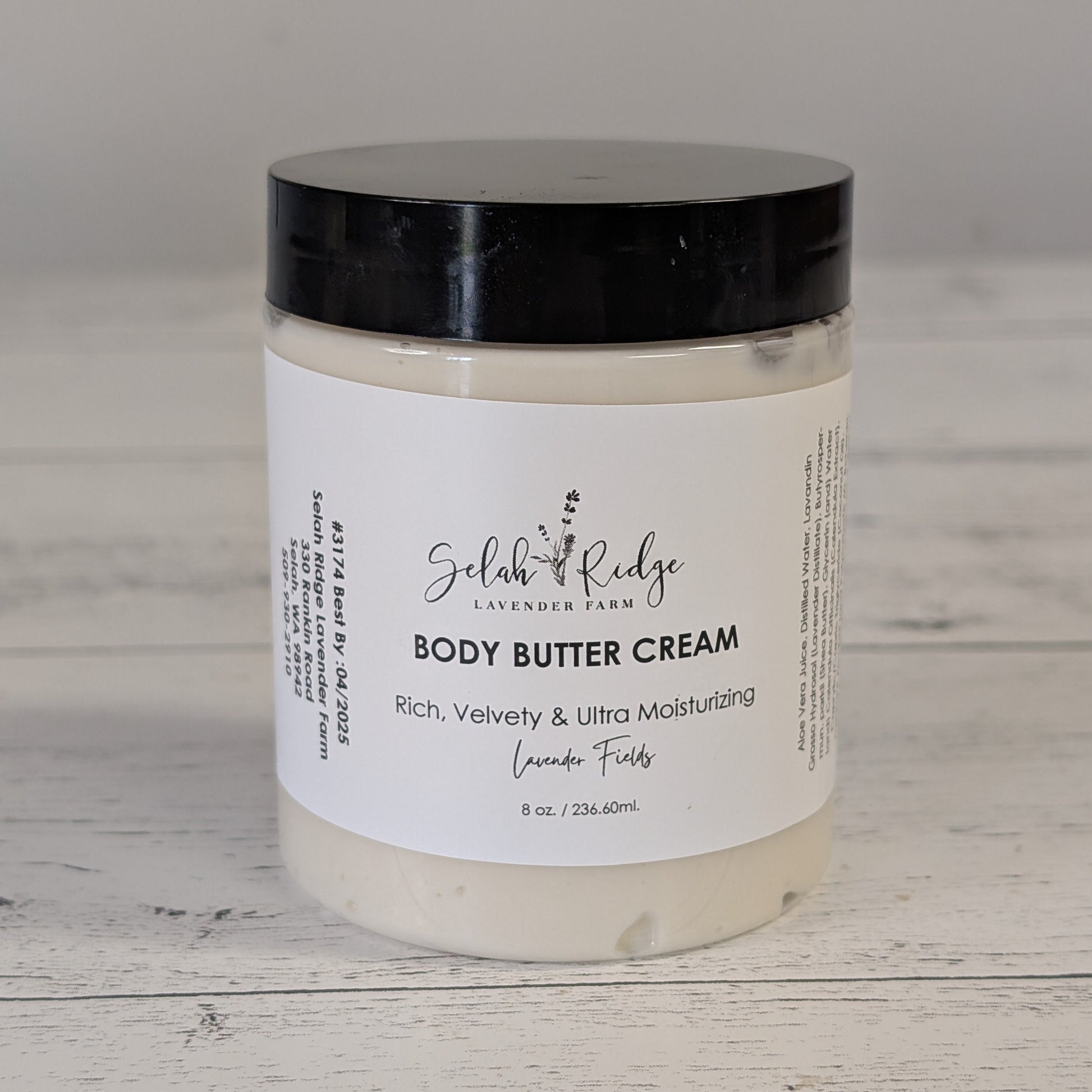 Body butter cream jar with black lid on a wooden surface
